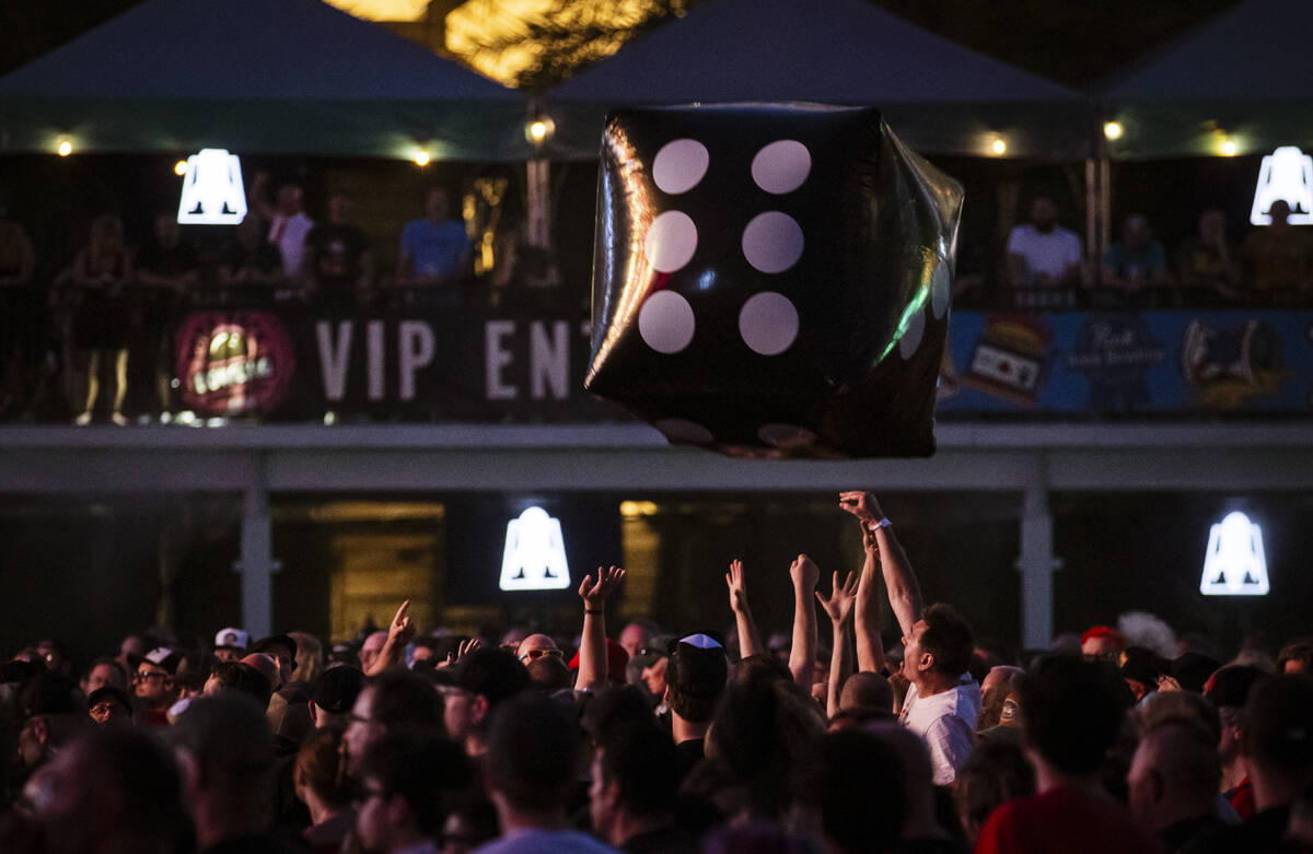 Festival attendees push an inflatable die into the air during the Punk Rock Bowling music festi ...