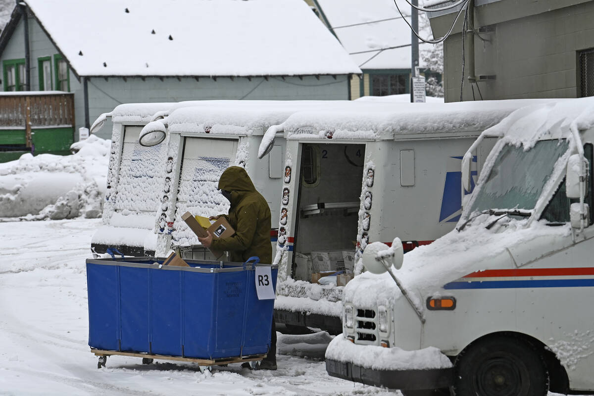 FILE - A mail carrier loads a mail truck with mail, March 1, 2024, in Lake Tahoe, Calif. The US ...