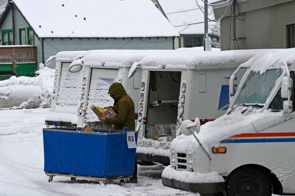 FILE - A mail carrier loads a mail truck with mail, March 1, 2024, in Lake Tahoe, Calif. The US ...