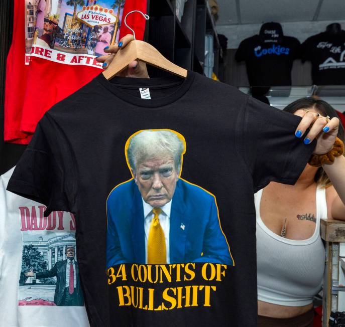 A vendor holds up a new t-shirt related to former President Donald Trump being convicted on 34 ...