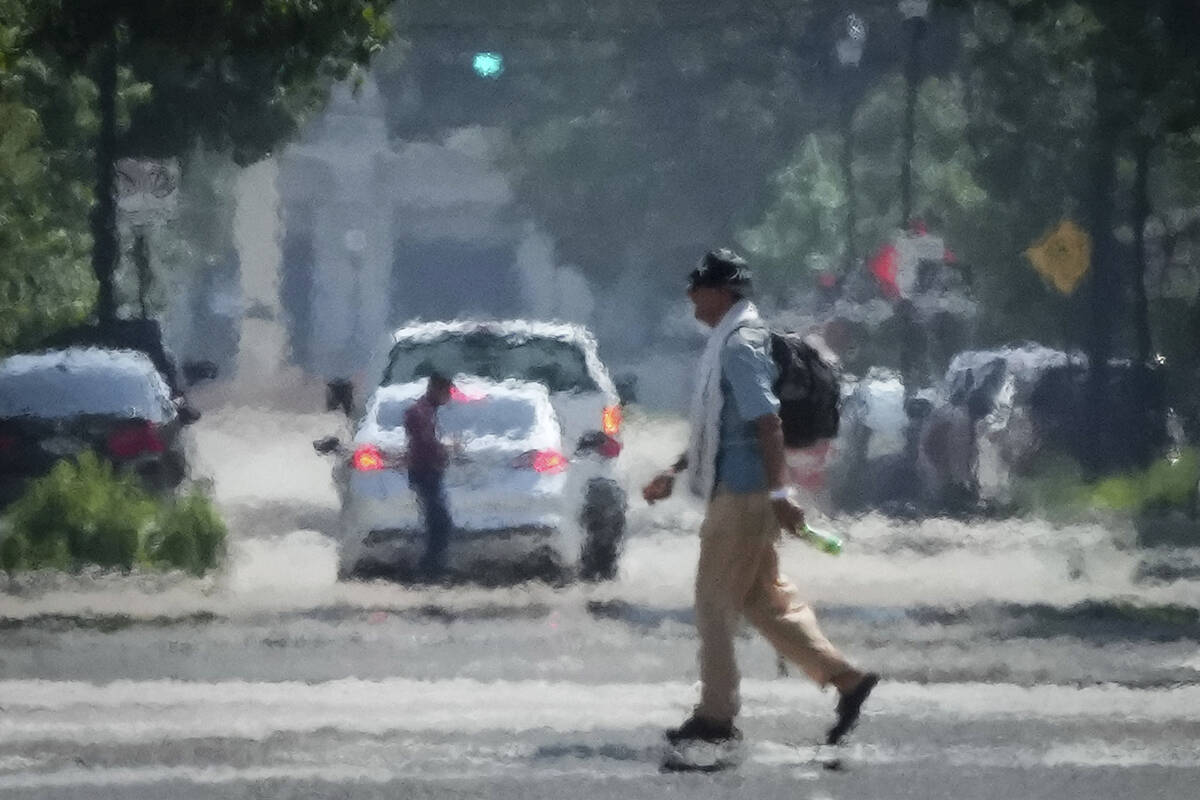 A person crosses Caroline Street in the afternoon heat Saturday, May 25, 2024, near Discovery G ...