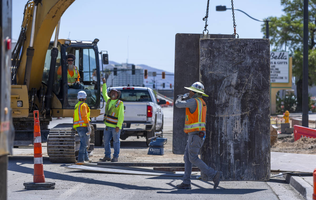 A construction worker drinks water on a road project along West Charleston Blvd. as he and othe ...