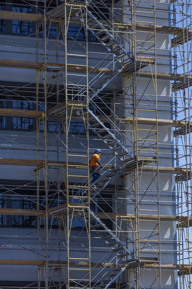 A construction worker walks up scaffold on a project about the UMC Surgery Center as he and oth ...