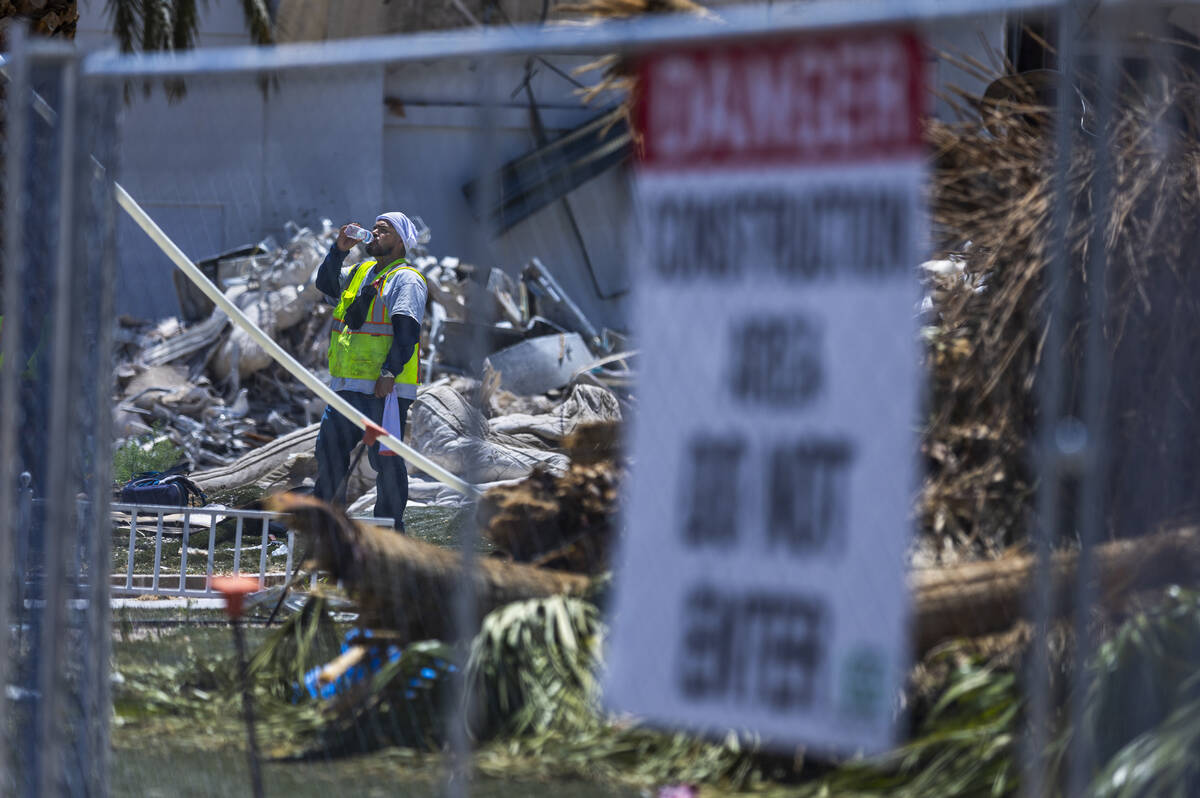 A crew member drinks water at the Tropicana Las Vegas demolition as workers use protections aga ...