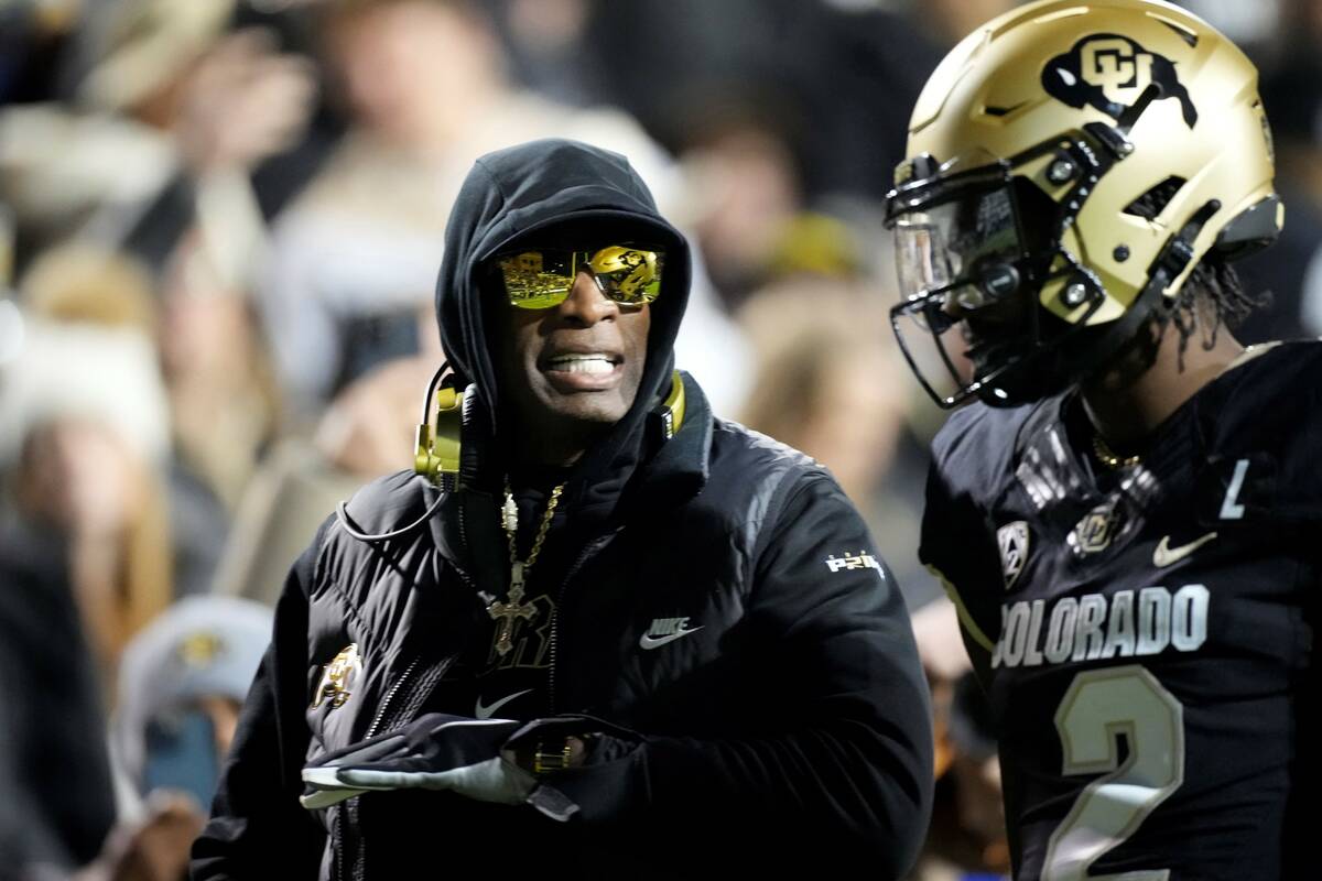 Colorado head coach Deion Sanders, left, talks to his son, quarterback Shedeur Sanders, in the ...