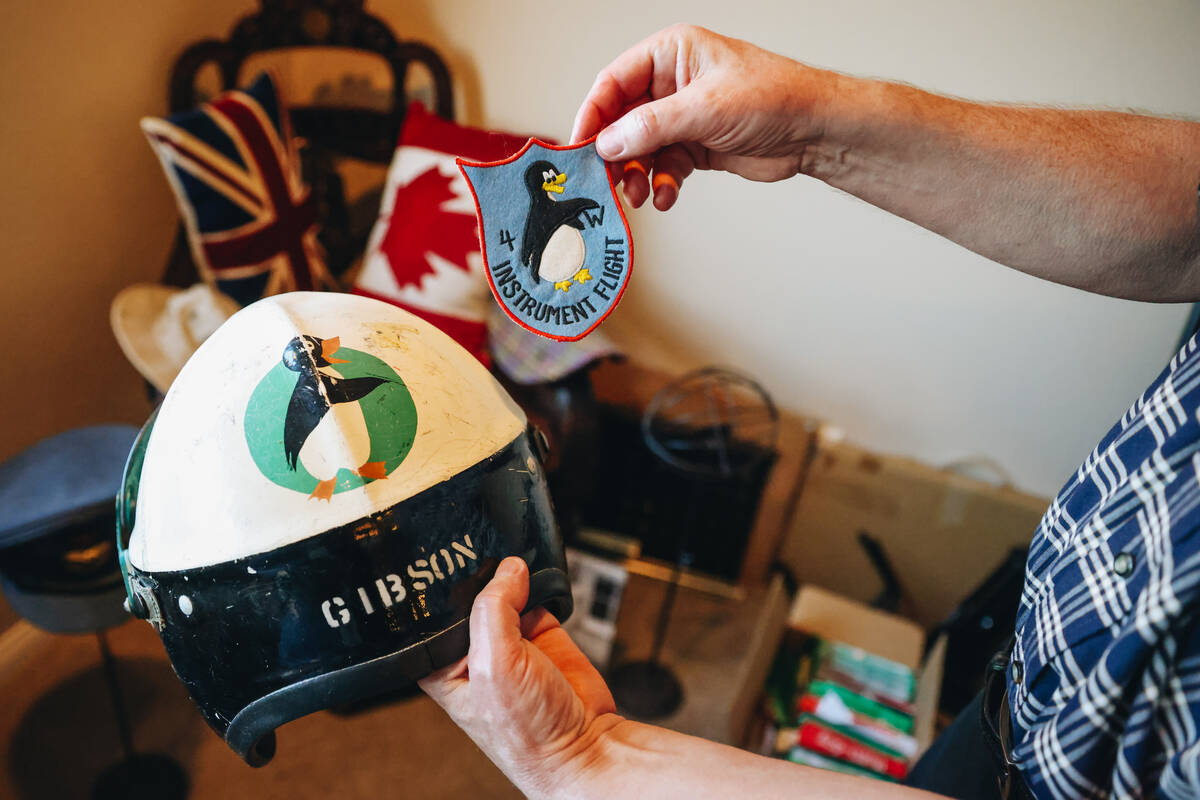 David Gibson holds up a patch and flight helmet that his father, Gordon Gibson, used after Worl ...