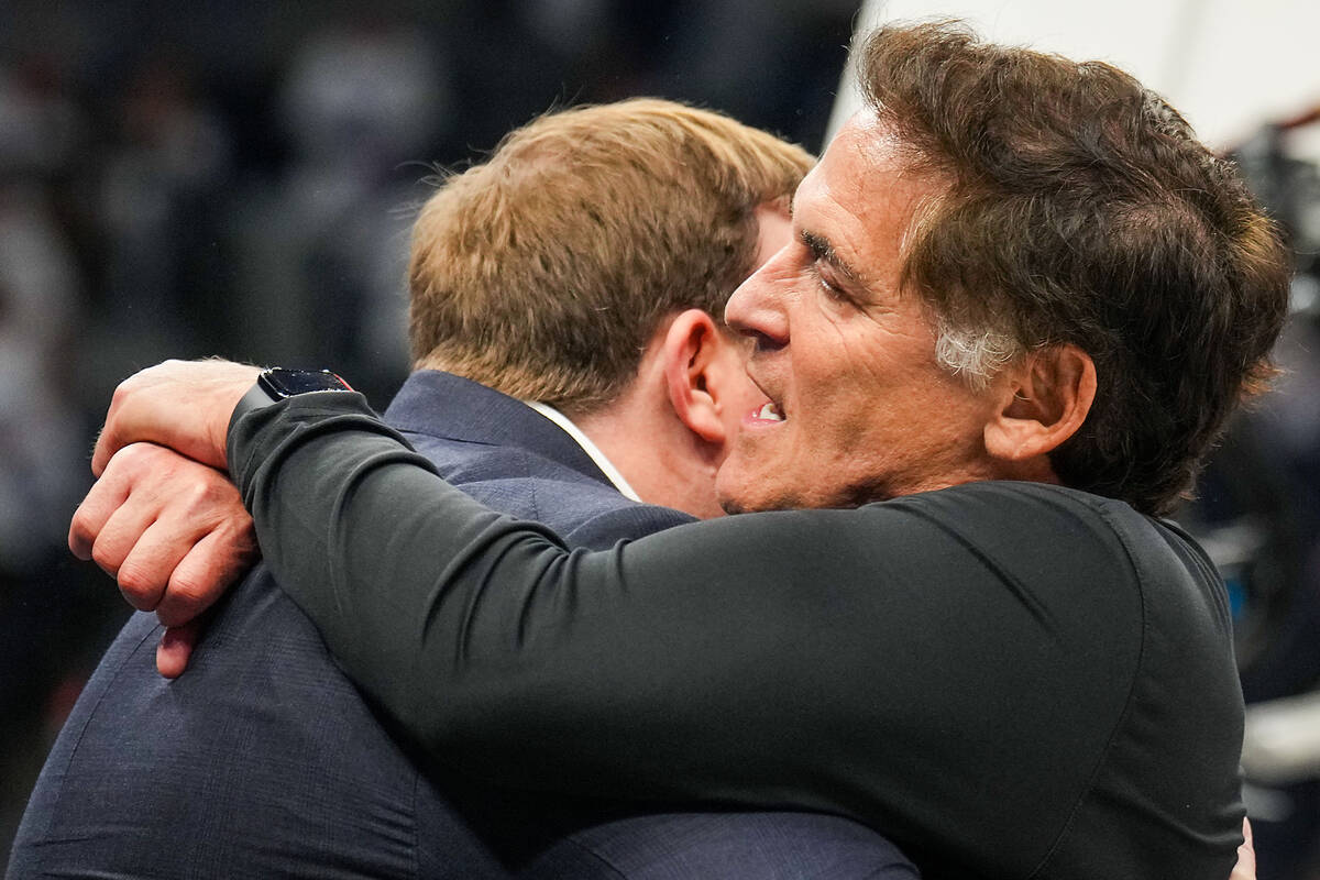 Dallas Mavericks minority owner Mark Cuban hugs governor Patrick Dumont in the final seconds of ...