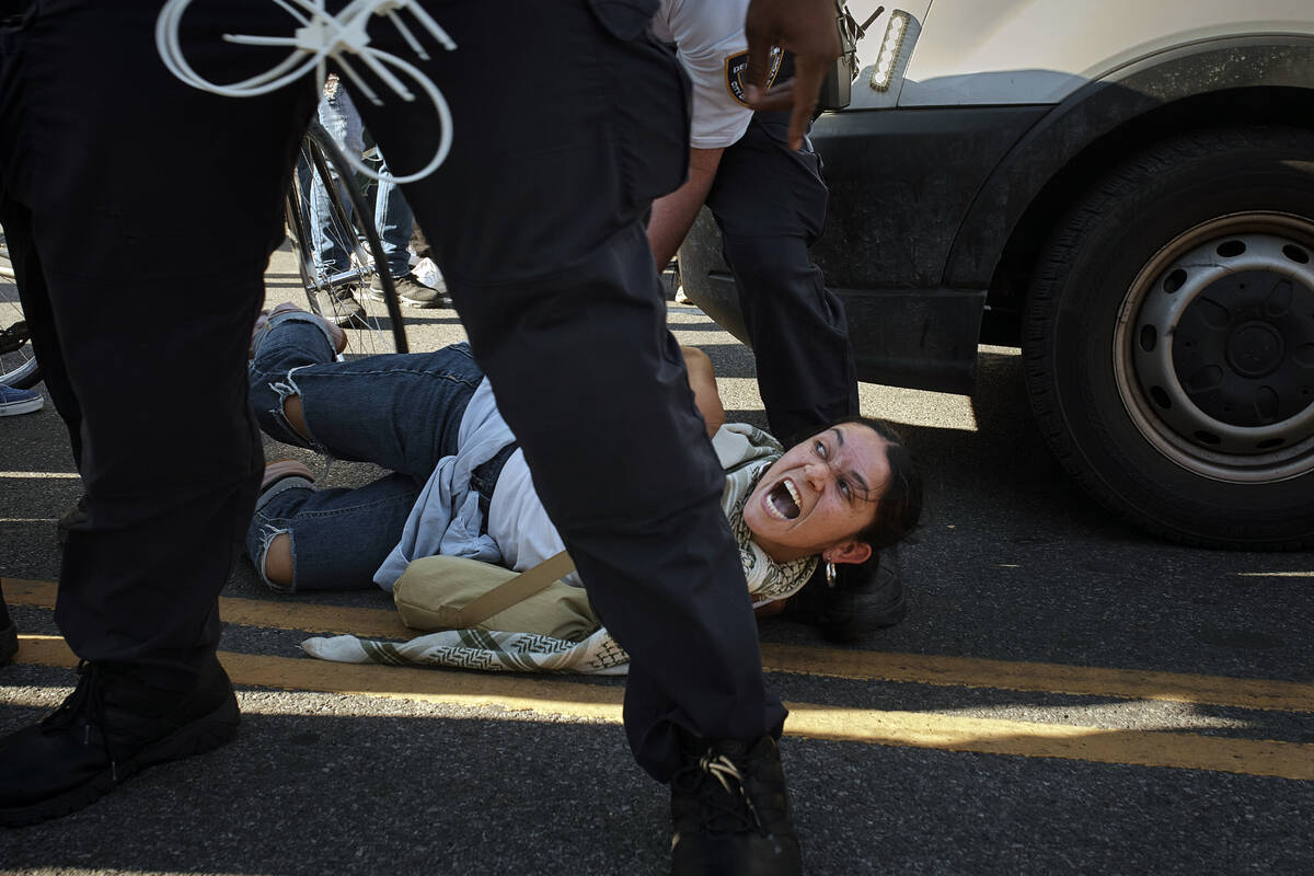 A pro-Palestinian demonstrator yells as a New York City police officer detains her during a pro ...