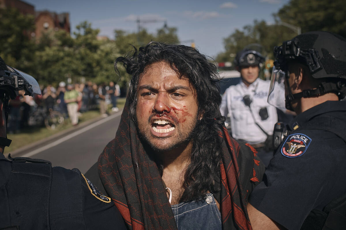 A pro-Palestinian demonstrator is detained by police during a protest demanding a permanent cea ...