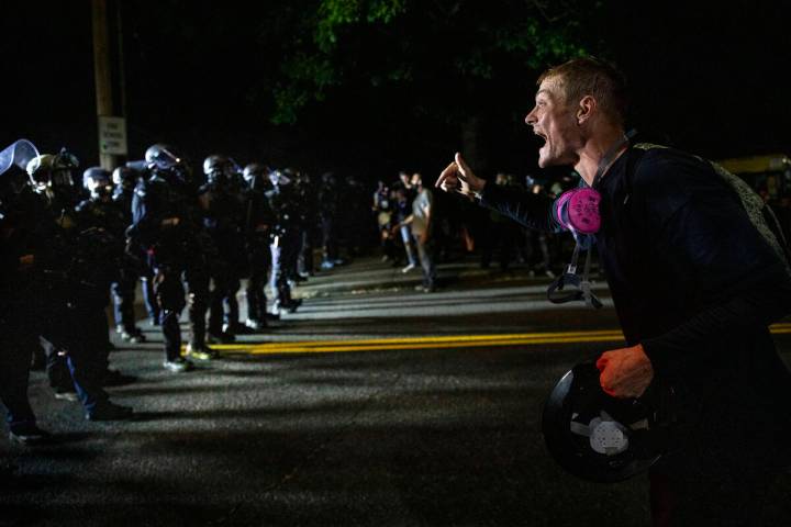 A protester screams at police as as Portland protests continue reaching 100 consecutive nights ...