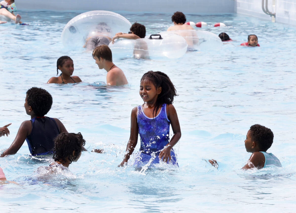 Parkgoers, including Delina Weldegebriel, 8, center, play on a hot day at Cadillac Shore Wave p ...