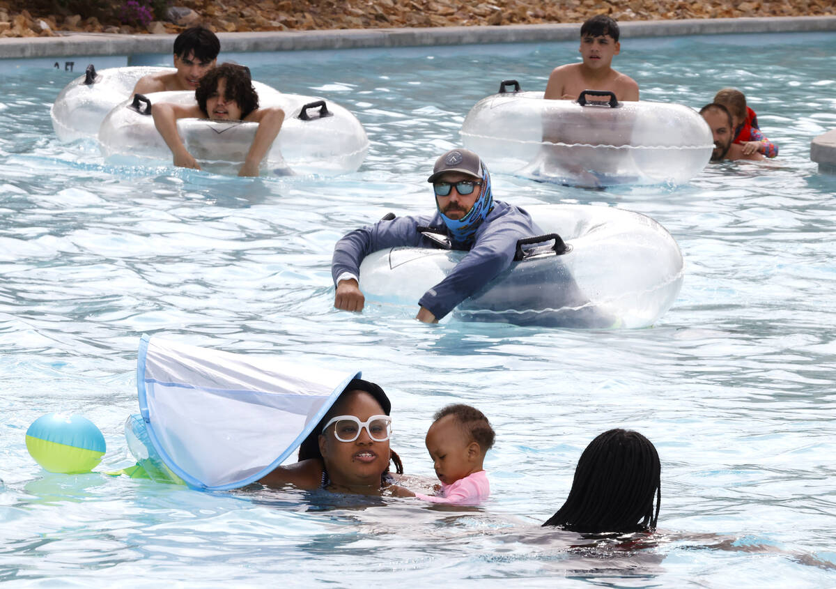 Parkgoers, including Shaniece West and her 11-month-old daughter, center, relax as they float o ...