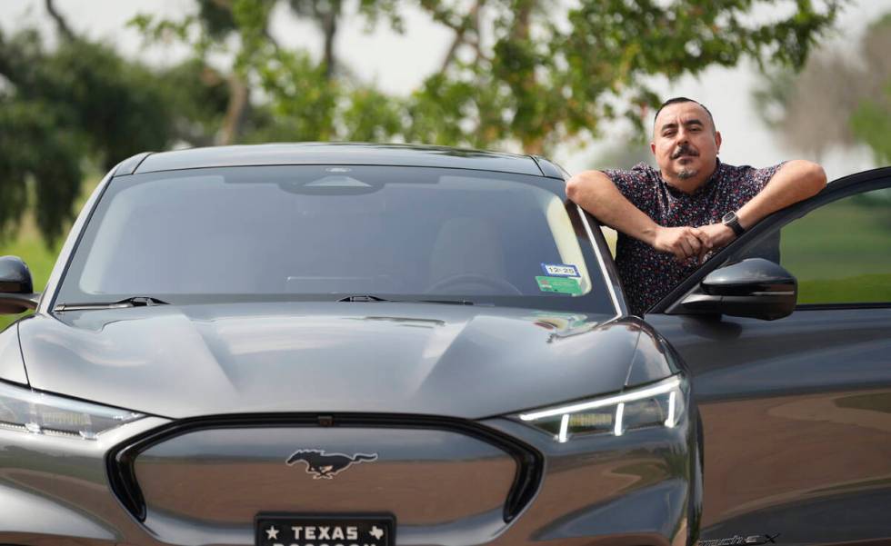 Jose Valdez, 45, who owns three EVs, poses with his Mustang Mach-E, Thursday, May 9, 2024, in S ...