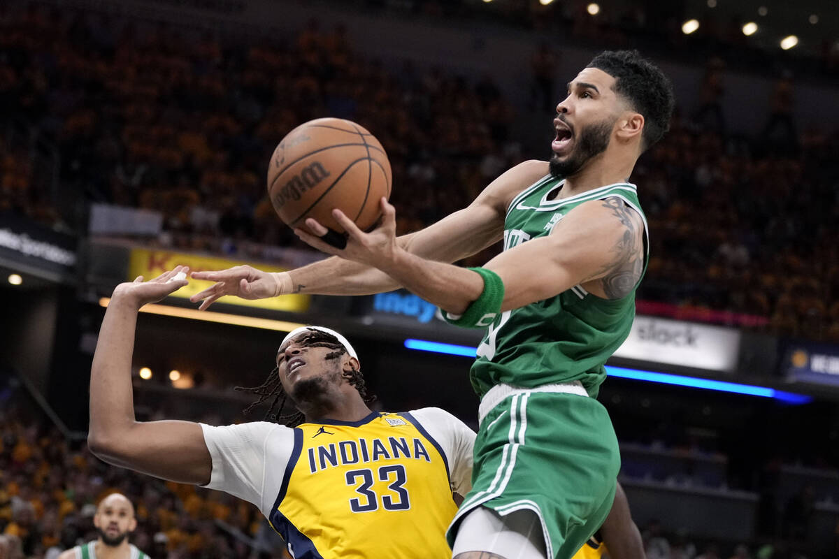 Boston Celtics forward Jayson Tatum (0) drives to the basket over Indiana Pacers center Myles T ...