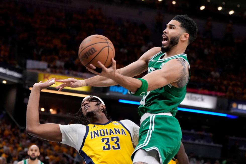 Boston Celtics forward Jayson Tatum (0) drives to the basket over Indiana Pacers center Myles T ...