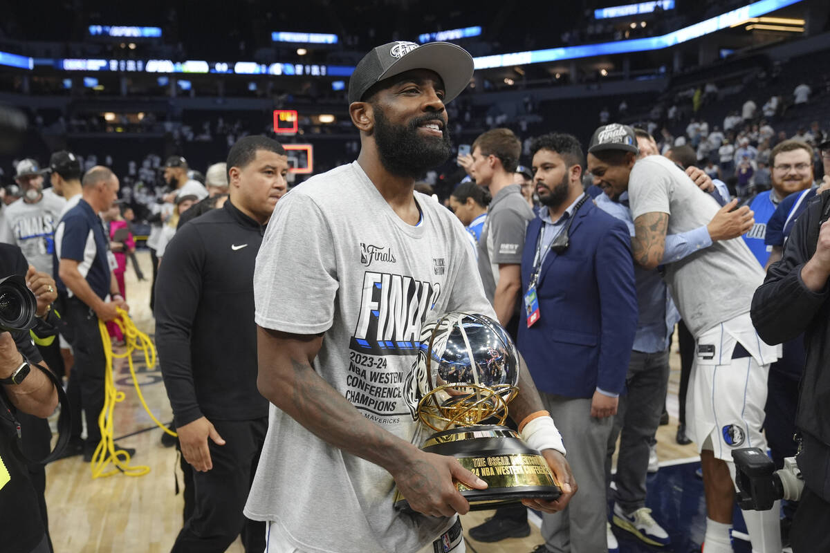Dallas Mavericks guard Kyrie Irving holds the Western Conference Trophy after Game 5 of the Wes ...