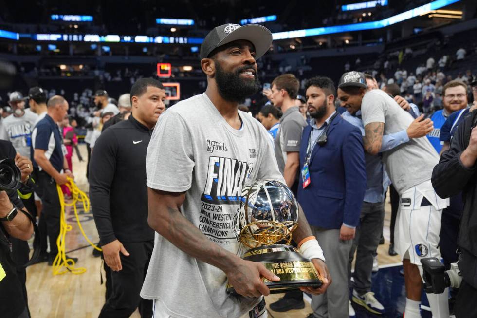Dallas Mavericks guard Kyrie Irving holds the Western Conference Trophy after Game 5 of the Wes ...
