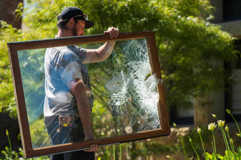 A campus maintenance worker carries a broken window from the office of the president at Stanfor ...