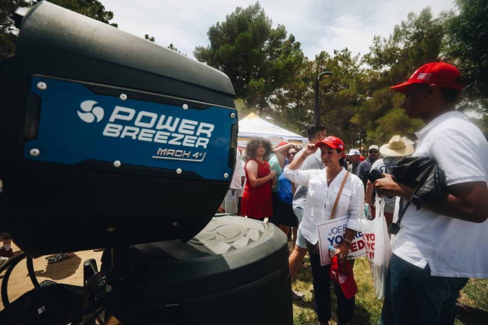 Trump supporters cool off by a misting fan at a rally for Former President Donald Trump at Suns ...