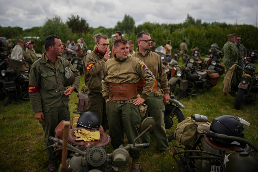 Reenactors riding US army vintage Harley Davidson motorbikes stop for a rest at Utah Beach near ...