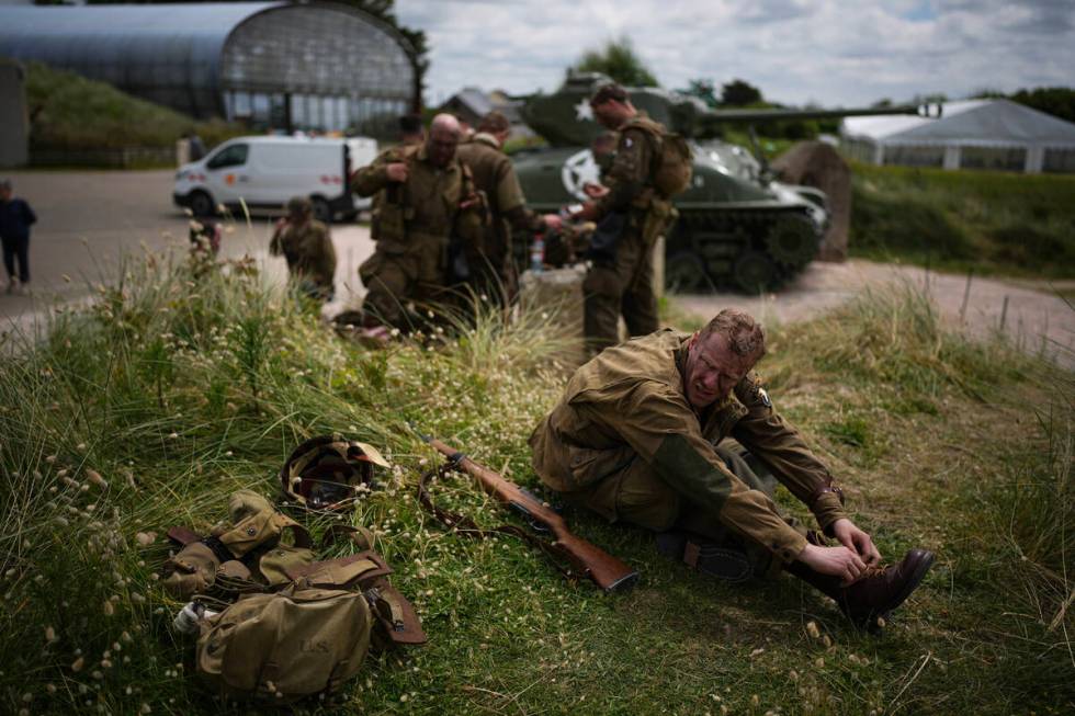 A reenactor rests at Utah Beach near Sainte-Marie-du-Mont, Normandy, France, Tuesday, June 4, 2 ...