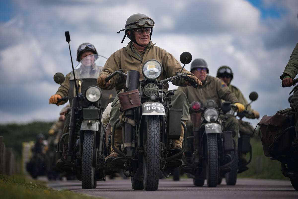 Reenactors ride US army vintage Harley Davidson motorbikes at Utah Beach near Sainte-Marie-du-M ...