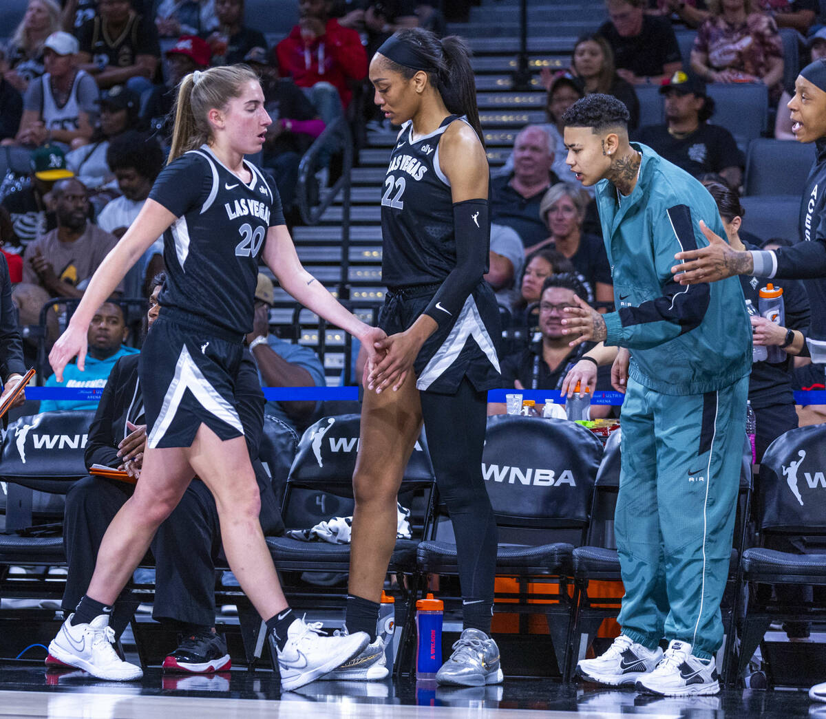 Aces guard Kate Martin (20) is greeted on the bench by center A'ja Wilson (22) and teammates ag ...