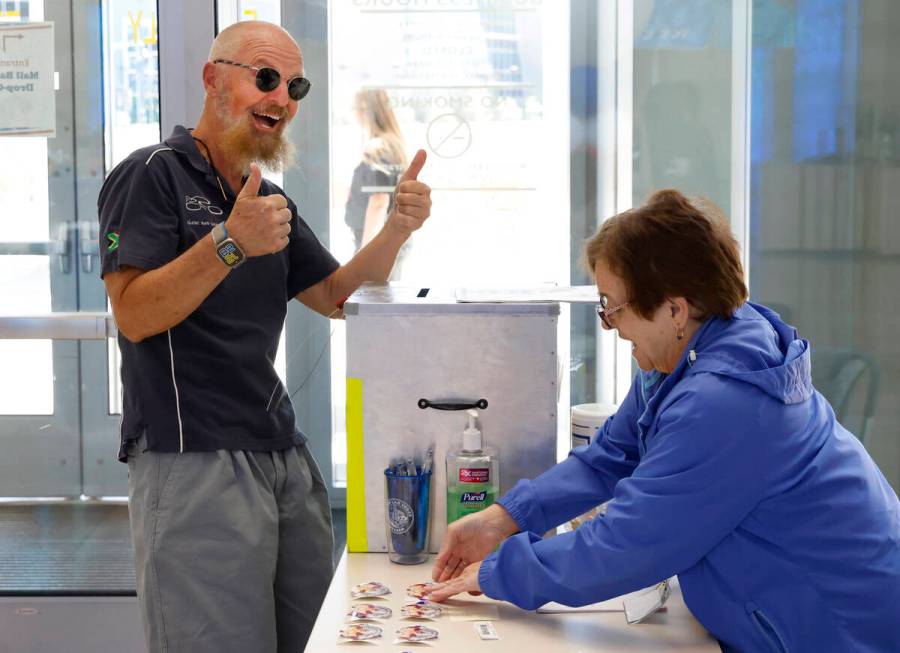 Beverly Mourachian, right, a volunteer poll worker, prepares to give "I Voted" sticke ...