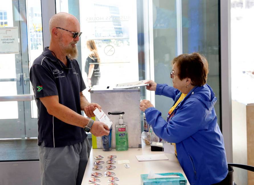 Beverly Mourachian, right, a volunteer poll worker, checks Bruce Leslie's sealed and signed bal ...