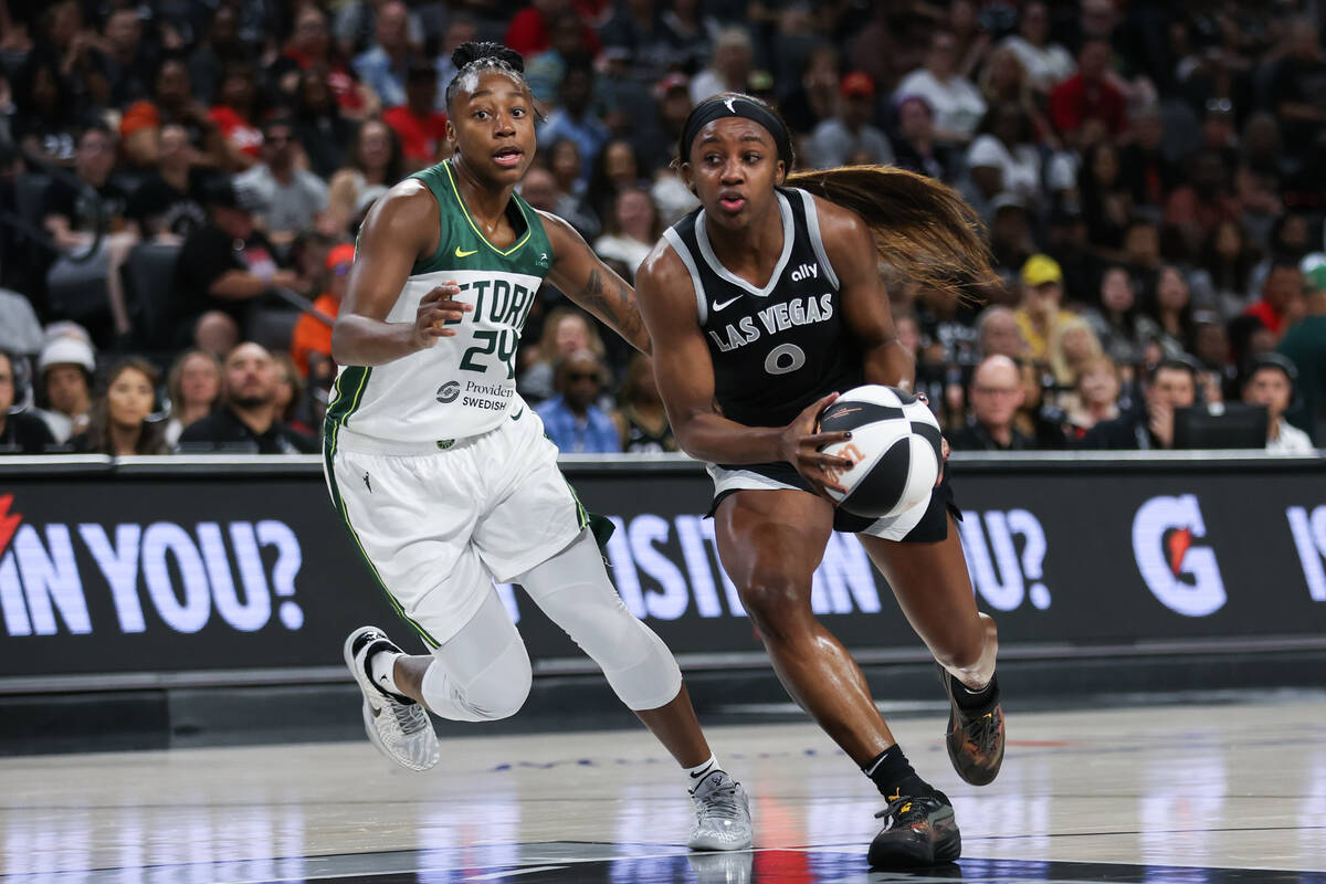 Las Vegas Aces guard Jackie Young (0) drives toward the hoop against Seattle Storm guard Jewell ...