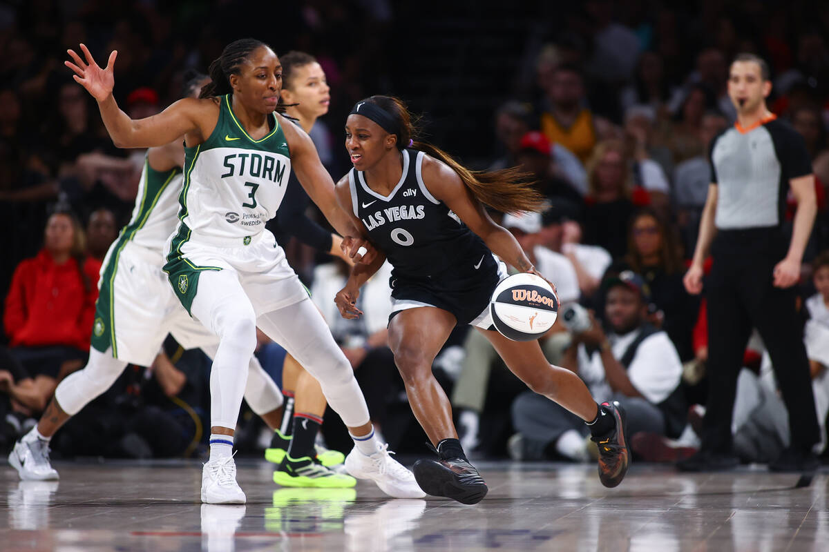 Las Vegas Aces guard Jackie Young (0) dribbles against Seattle Storm forward Nneka Ogwumike (3) ...