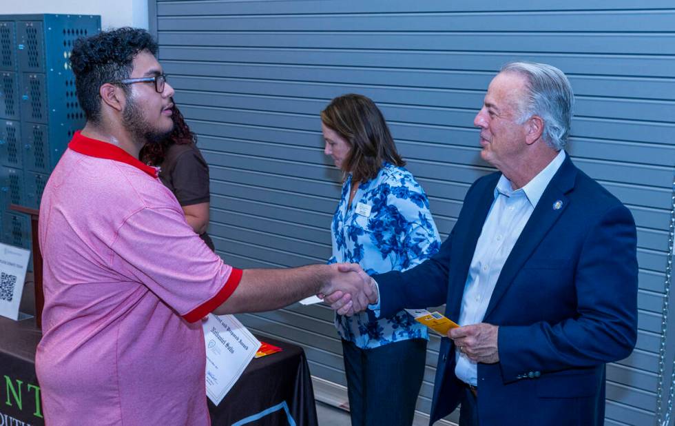 Student Nathaniel Solis shakes hands with Governor Joe Lombardo after receiving an award for be ...