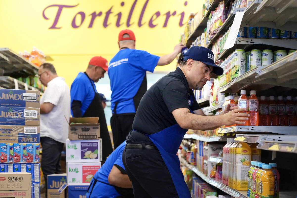 Employees stock shelves while preparations continue Friday, June 7, 2024, for the reopening of ...