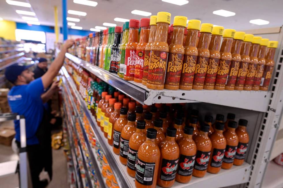 Workers stock shelves with hot sauce while preparations continue Friday, June 7, 2024, for the ...