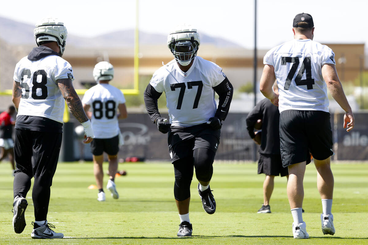 Raiders players, including offensive Tackle Thayer Munford Jr. (77) warm up during organized te ...