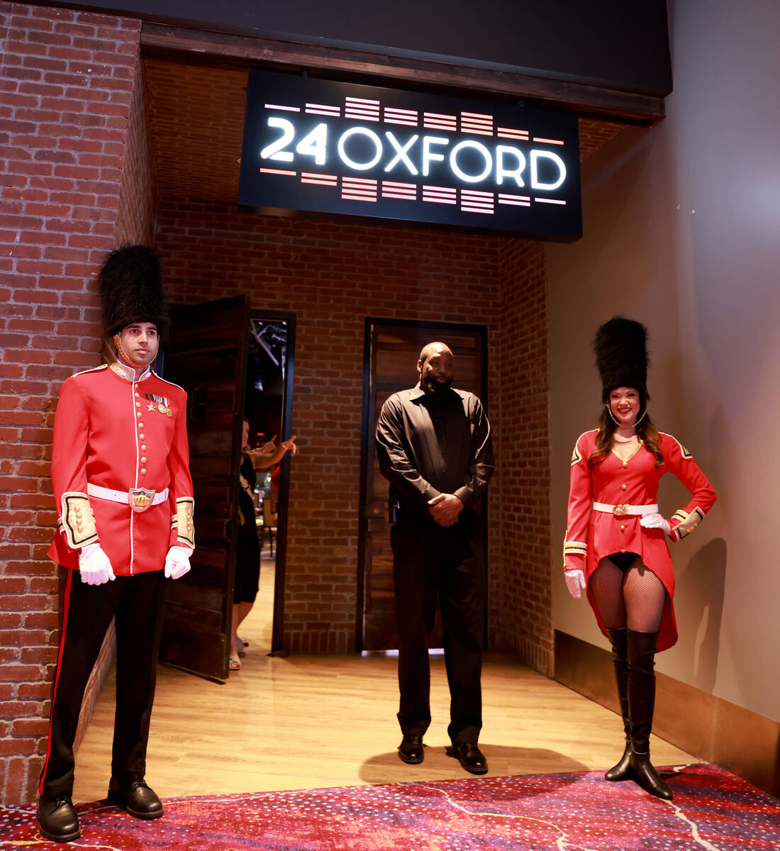 Models dressed as Beefeaters, who declined to give their names, welcome guests to a press confe ...