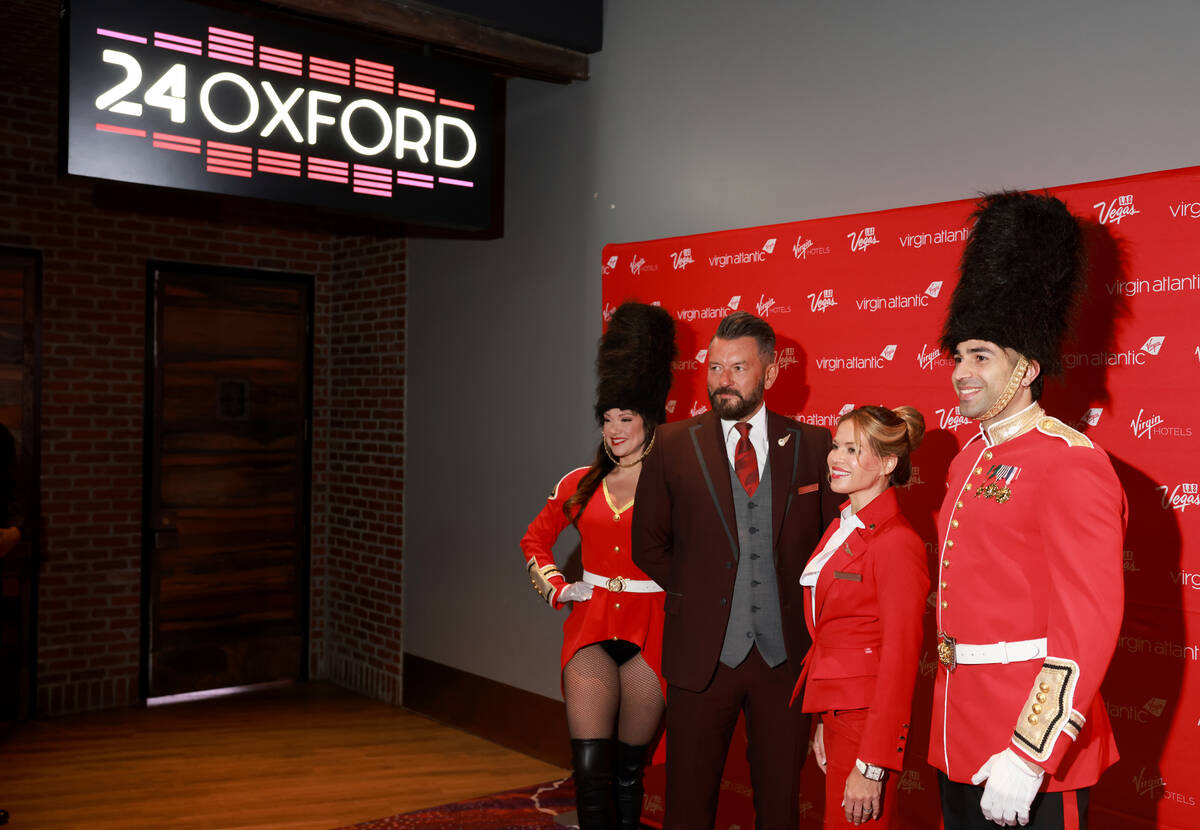 Models dressed as Beefeaters and crew members, who declined to give their names, pose for guest ...
