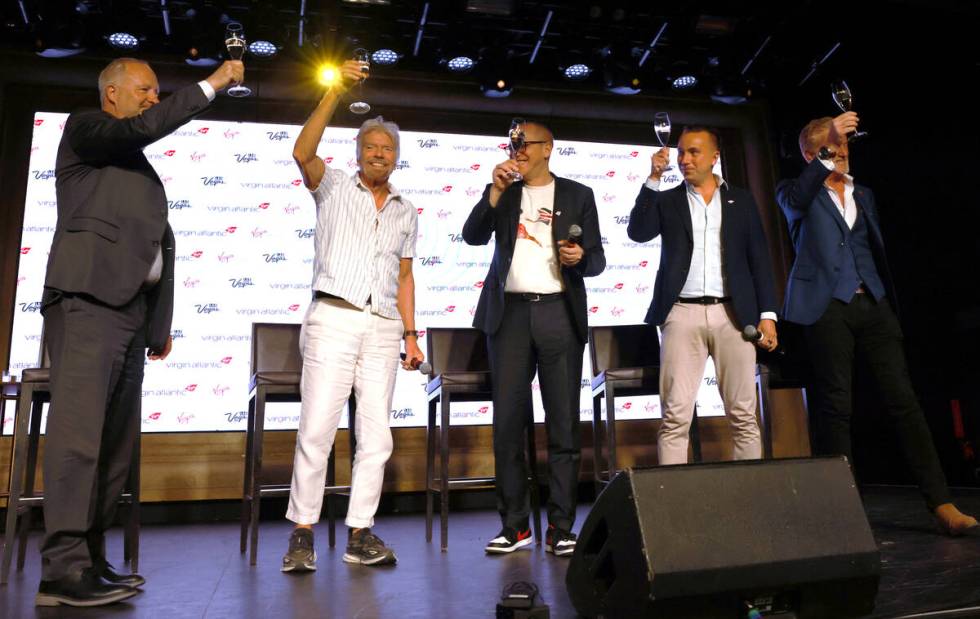 Sir Richard Branson, second from left, president and founder of Virgin Group, toasts, from left ...