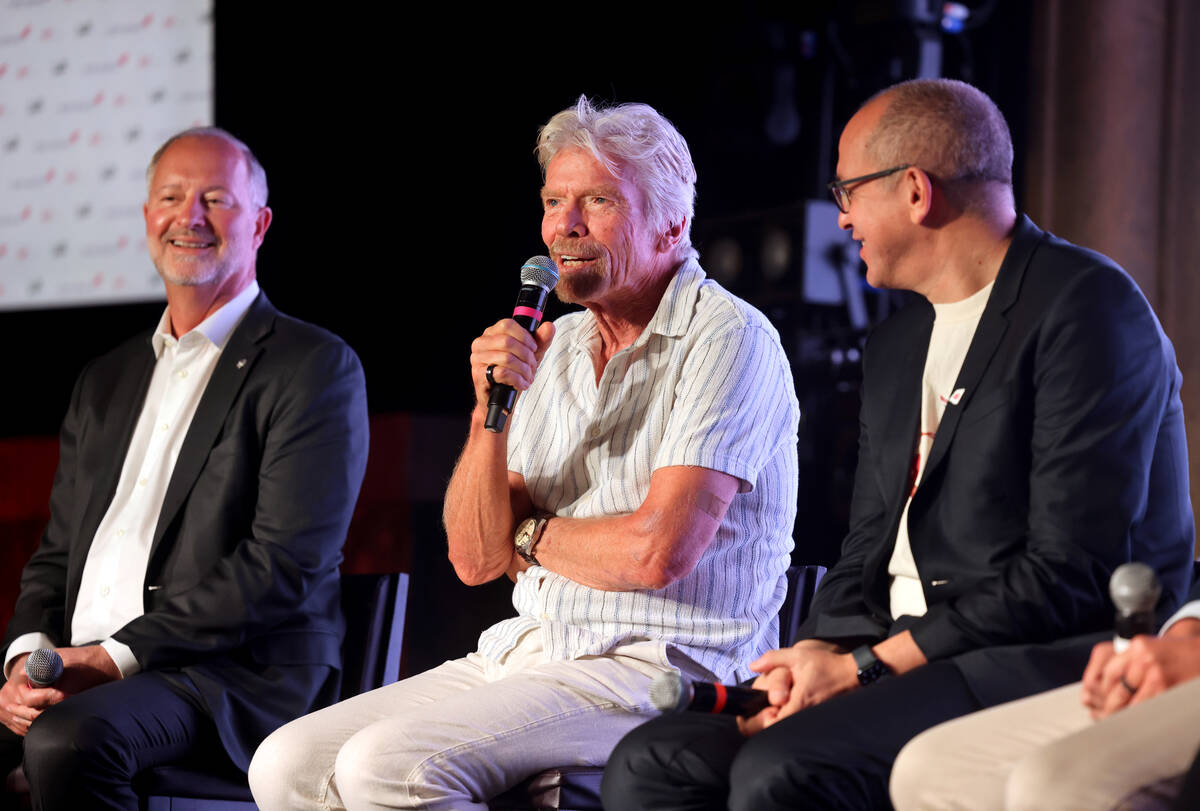 Sir Richard Branson, president and founder of Virgin Group, center, talks about the launch of ...