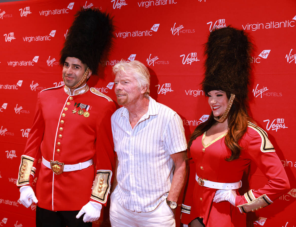 Sir Richard Branson, president and founder of Virgin Group, center, poses with models dressed ...
