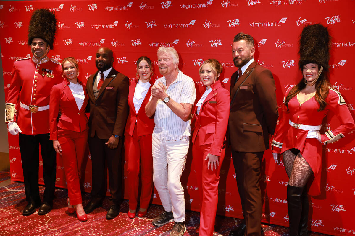 Sir Richard Branson, president and founder of Virgin Group, center, poses with crew members and ...