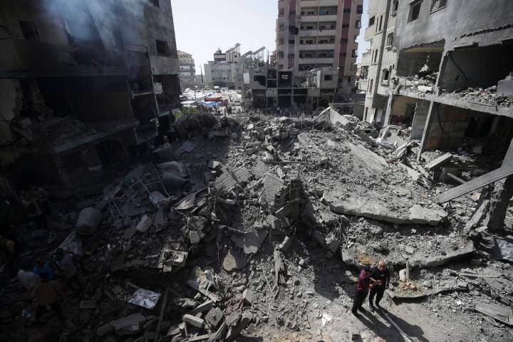 Palestinians look at the aftermath of the Israeli bombing in Nuseirat refugee camp, Gaza Strip, ...