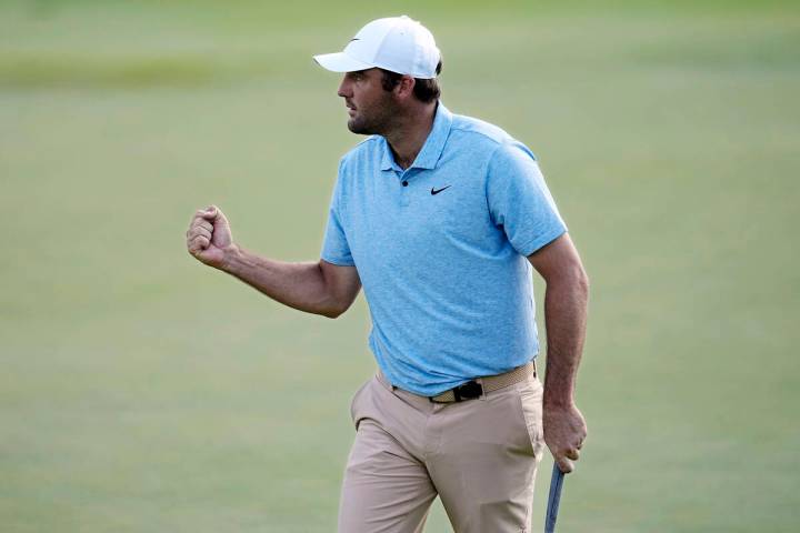 Scottie Scheffler pumps his fist after putting on the 16th green during the final round of the ...