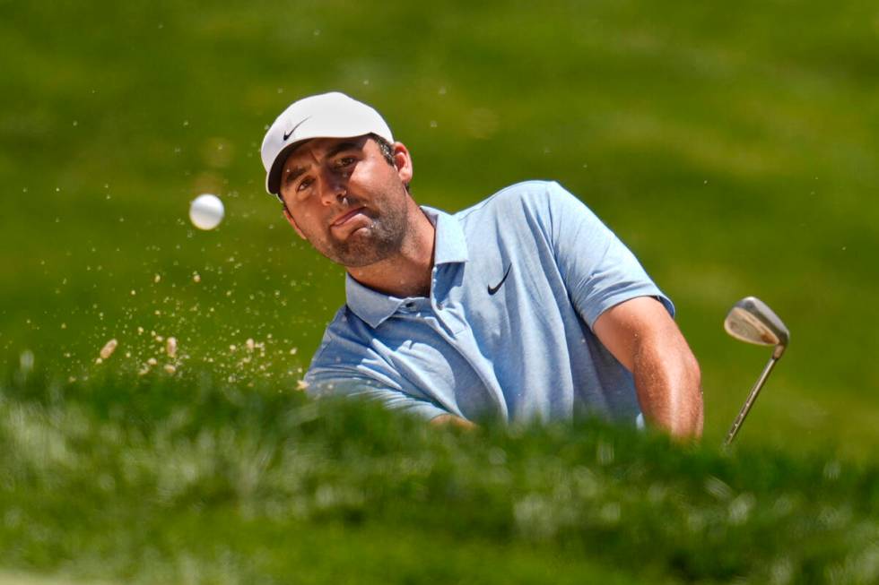 Scottie Scheffler hits from a bunker onto the fourth green during the final round of the Memori ...