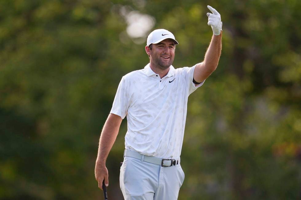 Scottie Scheffler gestures for someone to clear the 18th fairway before hitting from the 18th t ...