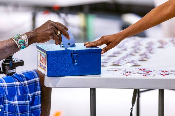 A voter deposits his polling machine card during Nevada's primary election day at the polls wit ...