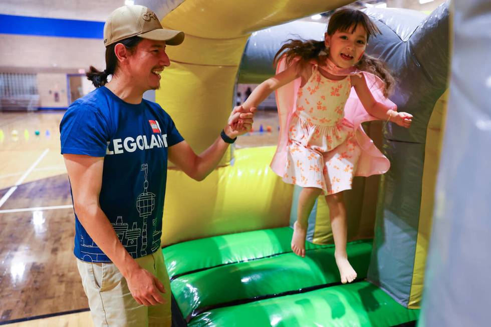 Ricardo Maldonado, of North Las Vegas, and his daughter Valentina Maldonado, 4, play in the bou ...