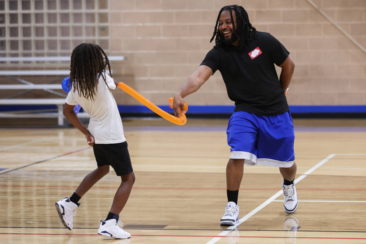 Keith O’Neal, of North Las Vegas, has a balloon sword fight with his son Keith O’ ...