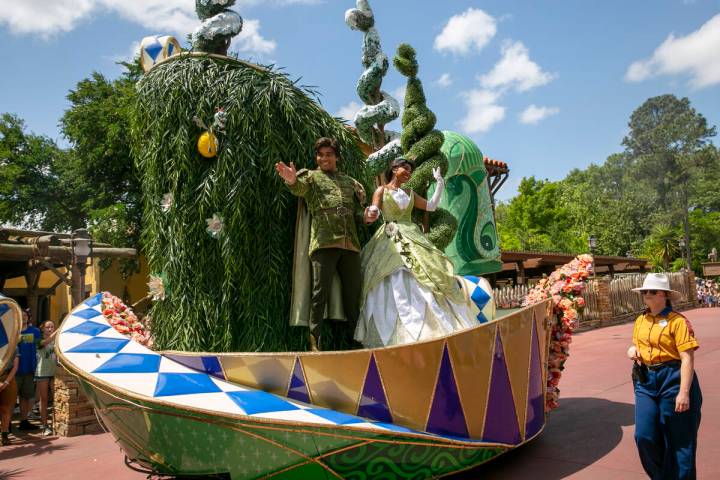 Actors dressed as Princess Tiana and Prince Naveen from The Princess and the Frog perform on a ...