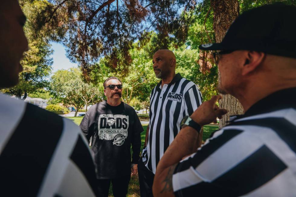 Troy Martinez, left, and L. Eric Culverson speak with fellow Dads in Schools volunteers at Fox ...